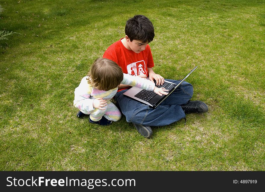Boy and the girl with the laptop,in the garden. Boy and the girl with the laptop,in the garden