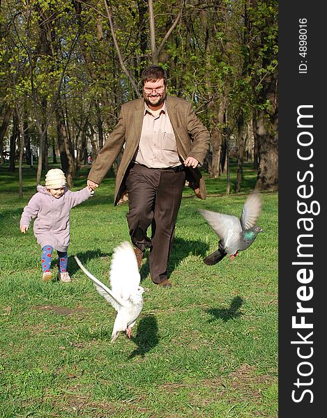 Man and girl running merrily forward holds their hands. Man and girl running merrily forward holds their hands