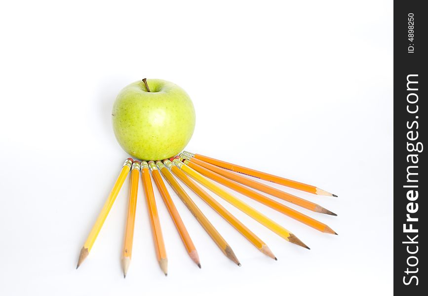 Colorful pencils and apple on white