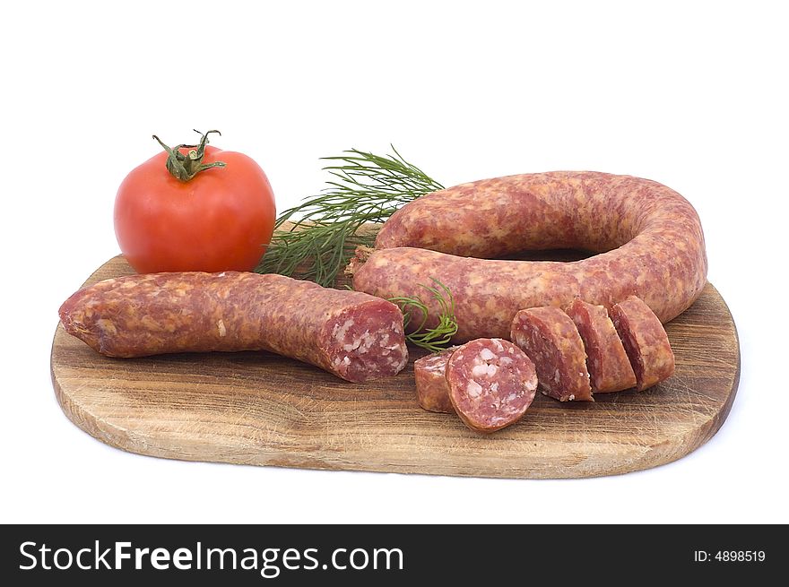 Sausage with tomato and dill on a wooden hardboard isolated on white