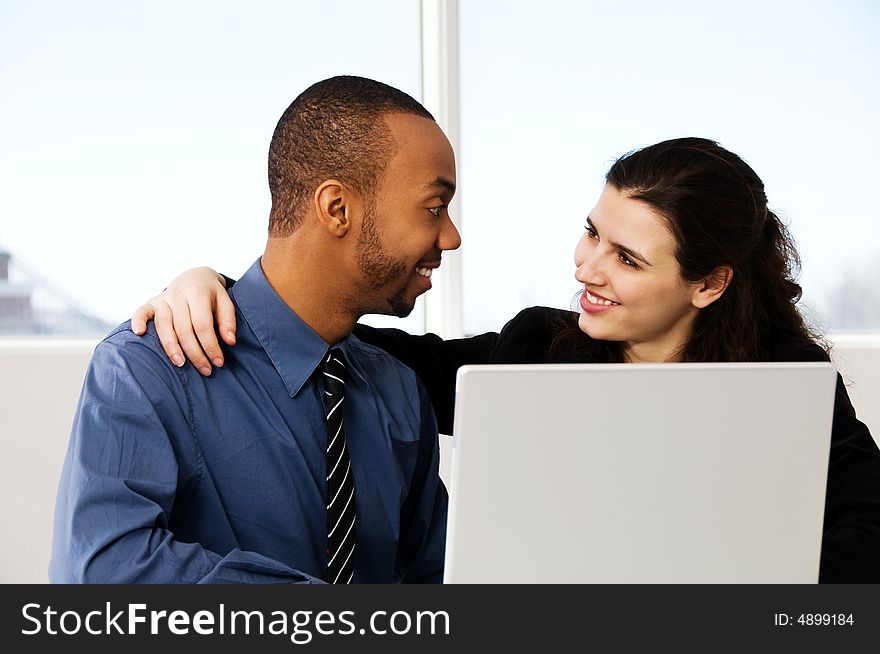 Two business associates with a grey laptop. Two business associates with a grey laptop