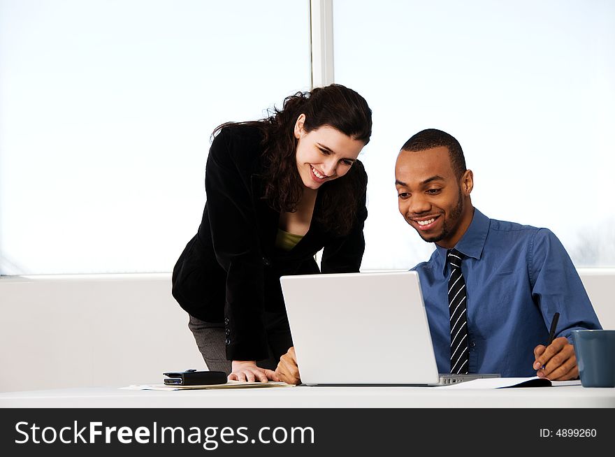 Two business associates with a grey laptop. Two business associates with a grey laptop