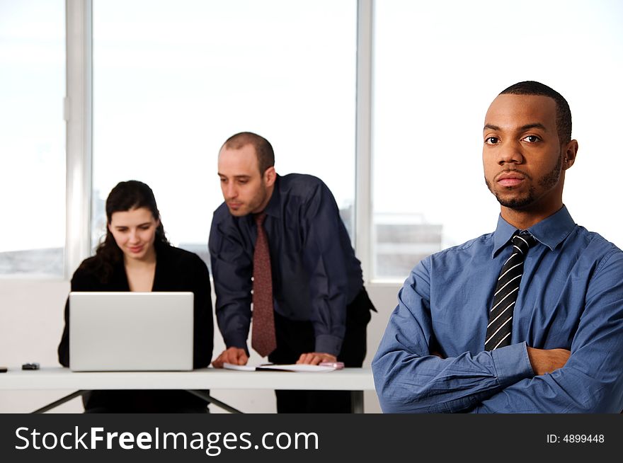 Three business associates with a grey laptop. Three business associates with a grey laptop