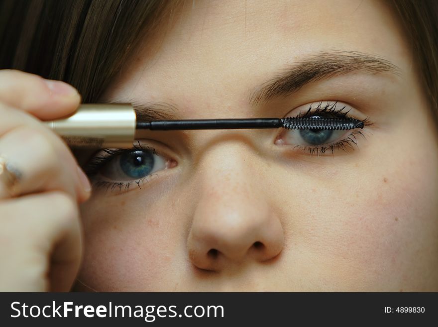 Young beautiful woman applying mascara. Young beautiful woman applying mascara