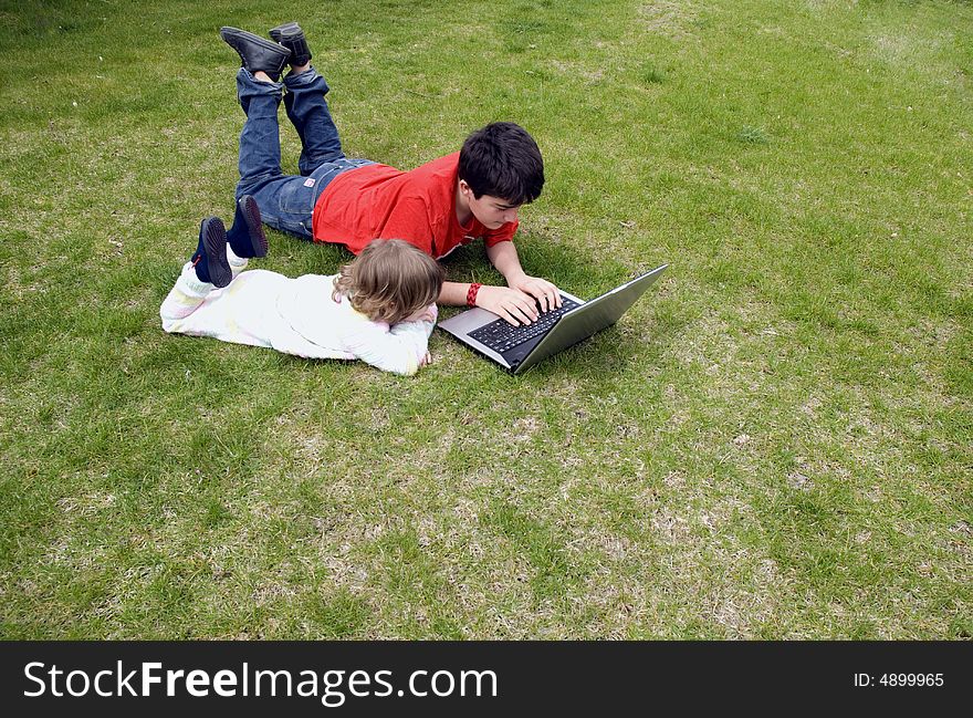 Boy and the girl with the laptop,in the garden. Boy and the girl with the laptop,in the garden