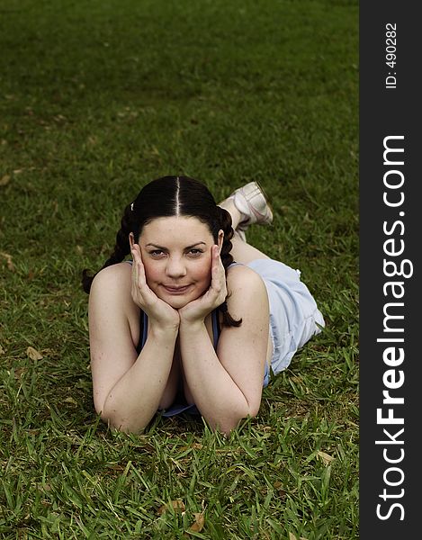 Young girl daydreaming in grass