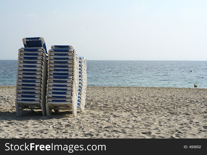 Sunbeds piled up at end of day on beach