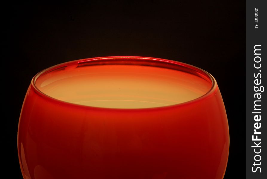 Top half of a red glass filled with white liquid. Top half of a red glass filled with white liquid