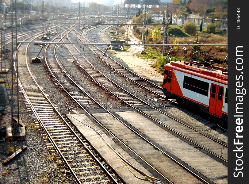 Colorful train arrives to station through a roadway of rails. Colorful train arrives to station through a roadway of rails