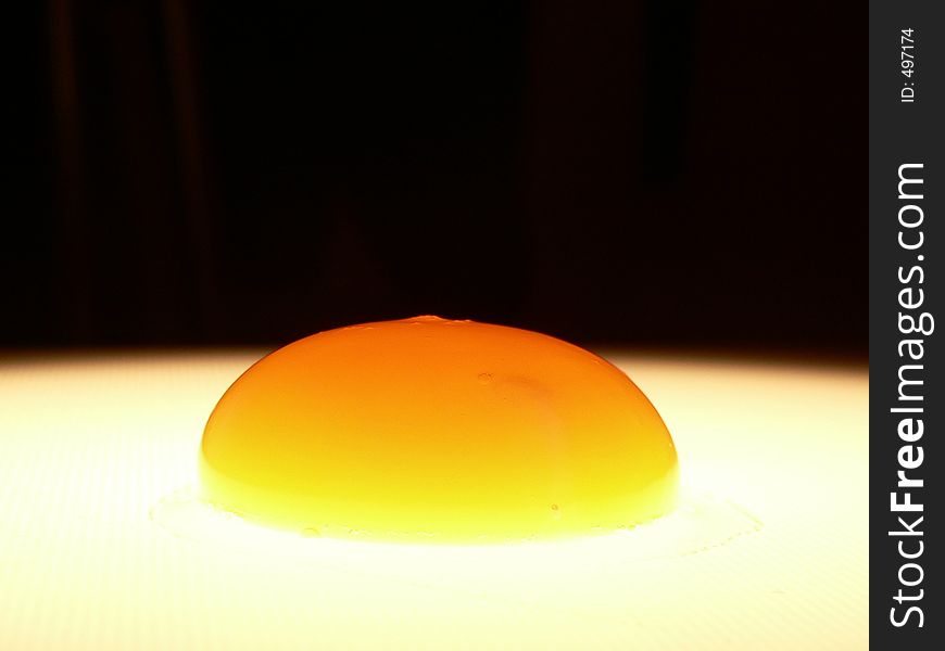 Raw yolk egg on white and black background