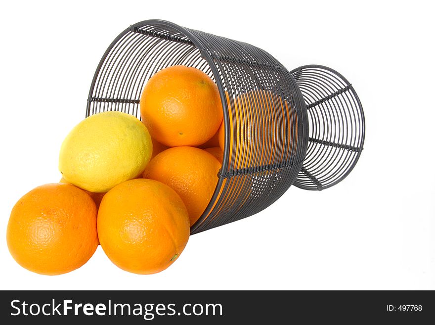 Oranges and a lemon fall out of a wire basket. Oranges and a lemon fall out of a wire basket
