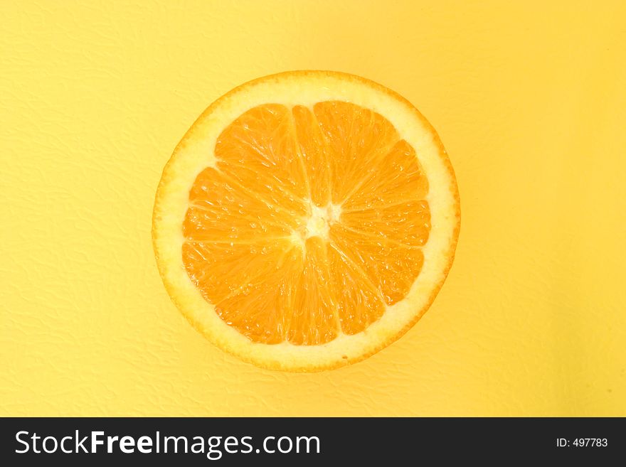 Half an orange on textured yellow background. Half an orange on textured yellow background