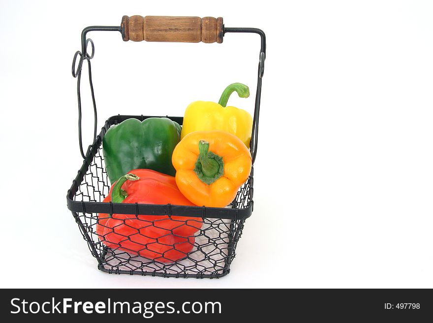 Several different kinds of peppers in a basket over white