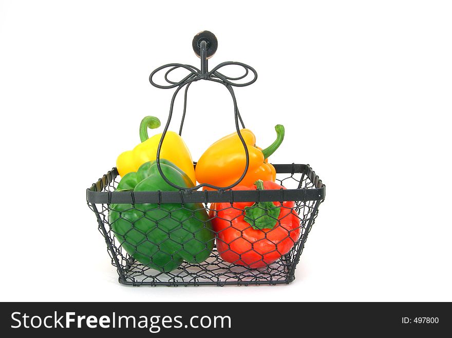 Variety of peppers in a wire basket over white. Variety of peppers in a wire basket over white