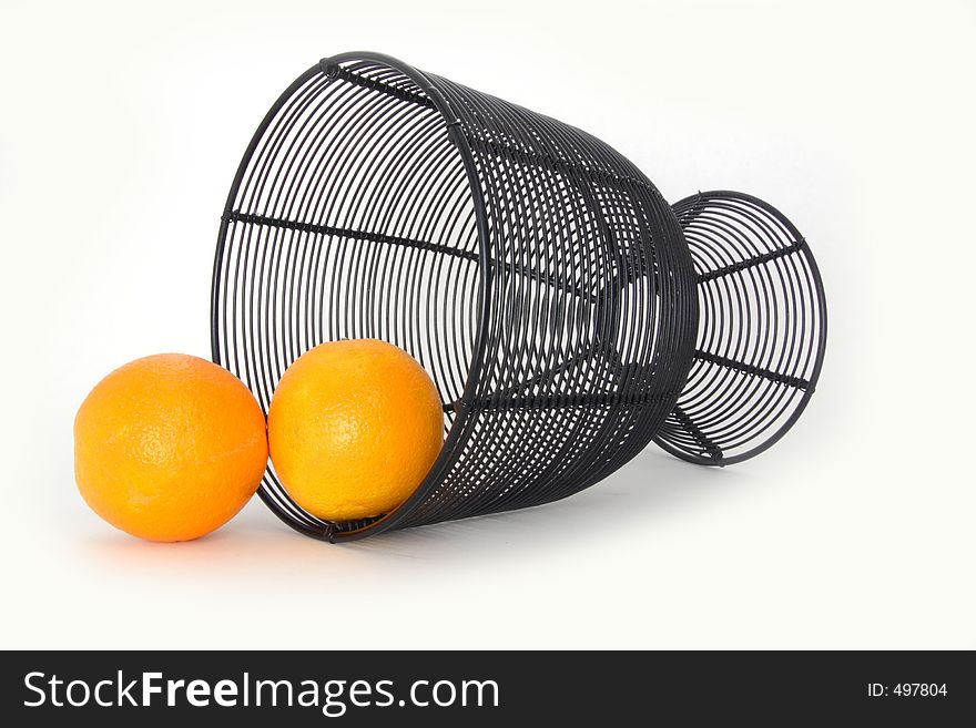 Oranges spilled from wire basket over white. Oranges spilled from wire basket over white