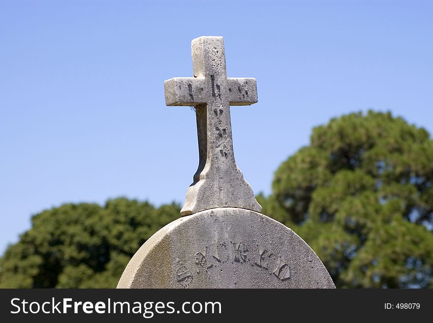 A weathered headstone with cross. A weathered headstone with cross