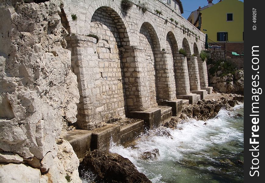 Water lapping over old stone arches in Rovinj, Croatia