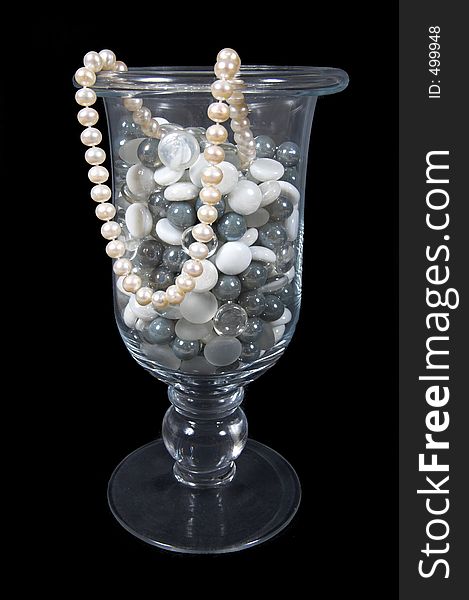 Vase full of marble stones with pearl necklace. Vase full of marble stones with pearl necklace