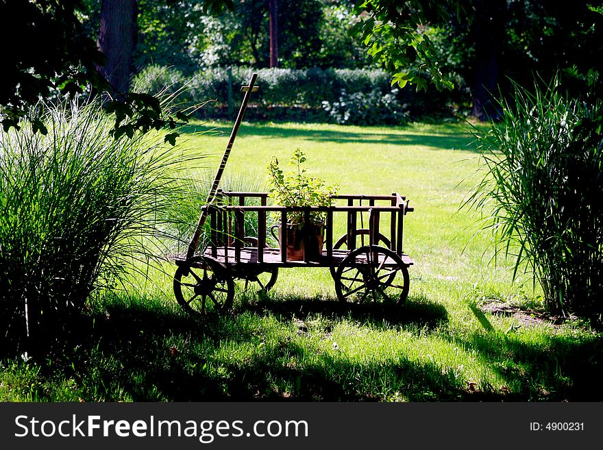 ChildrenÂ´s  wagon in a garden. ChildrenÂ´s  wagon in a garden