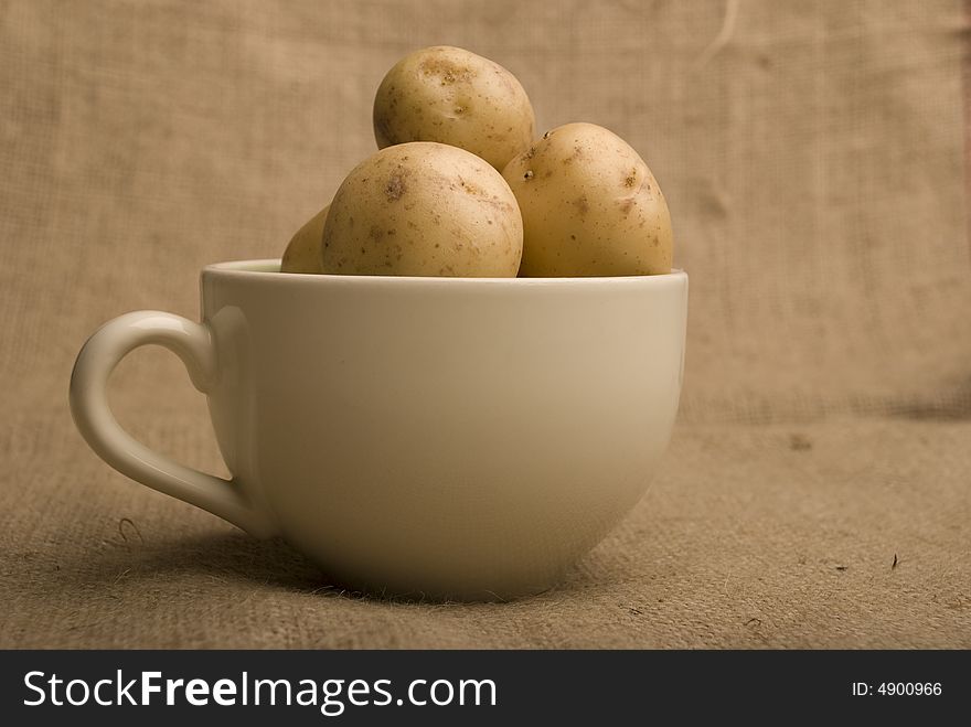 White bowl of m peer potatoes on sack