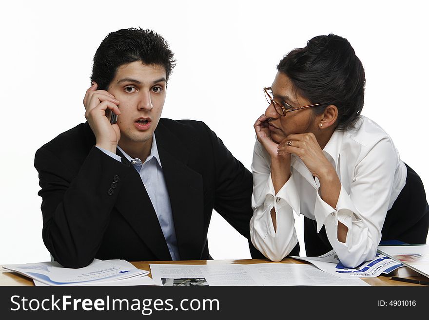 Male and female colleagues working together. He's getting bad news on the phone. Male and female colleagues working together. He's getting bad news on the phone