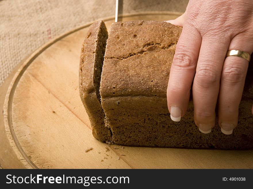 Woman Slicing Loaf Of Rye Bread