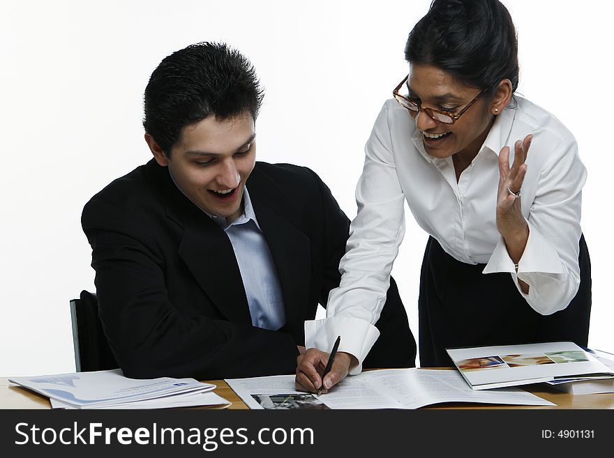 Male and female business colleagues with mouths open in excitement reviewing a document together. Male and female business colleagues with mouths open in excitement reviewing a document together