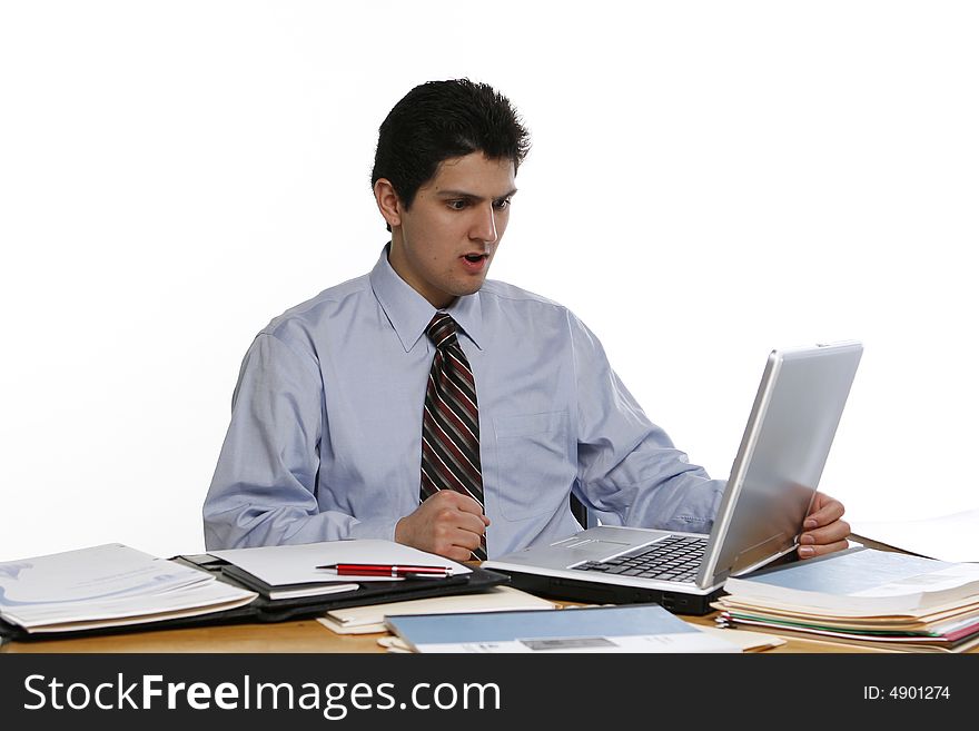 Business man sitting at his laptop with his fists clenched looking angry. Business man sitting at his laptop with his fists clenched looking angry