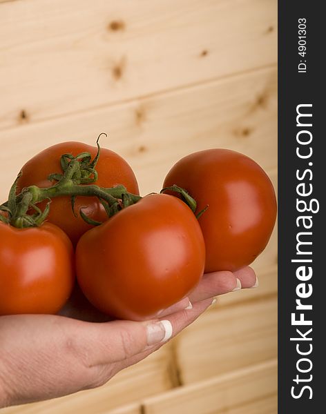 Female hand holding four organic tomatoes