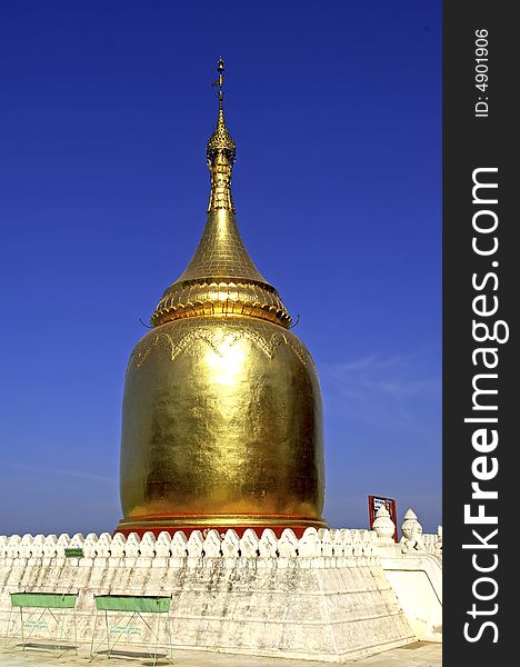 Myanmar, Bagan: blue sky and a view of the monastery roofs with a golden stupa. Myanmar, Bagan: blue sky and a view of the monastery roofs with a golden stupa