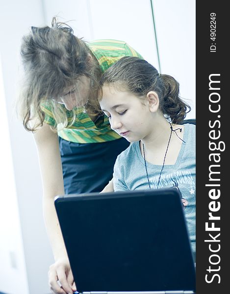 Teen girl learning computers from her sister