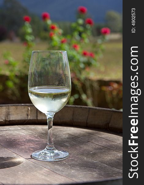 A glass of white wine on a wine barrel. A glass of white wine on a wine barrel.