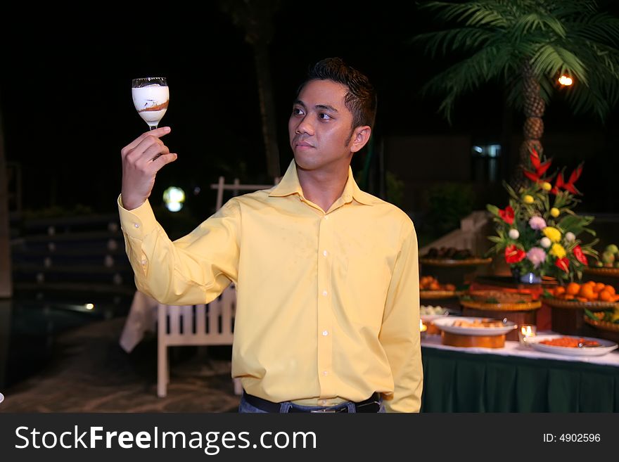 Man or waiter holding glass with food in it at outdoor dinner buffet