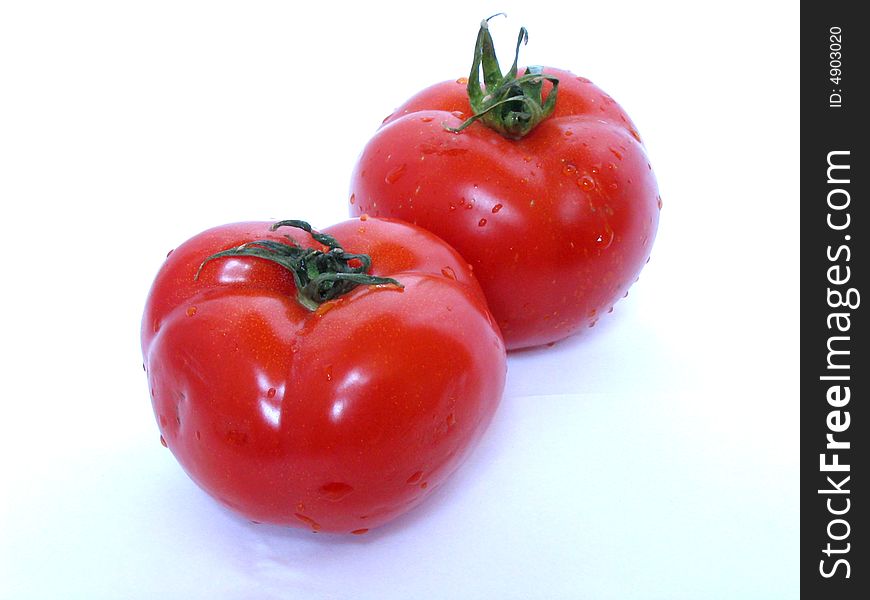 Two fresh red tomatoes on a white background. Two fresh red tomatoes on a white background