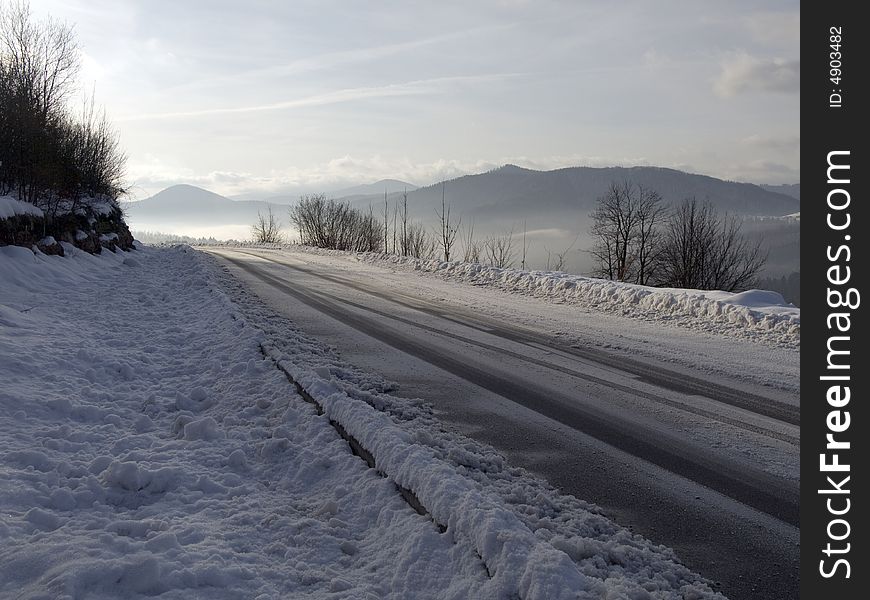 Mountain road in early morning covered with snow.