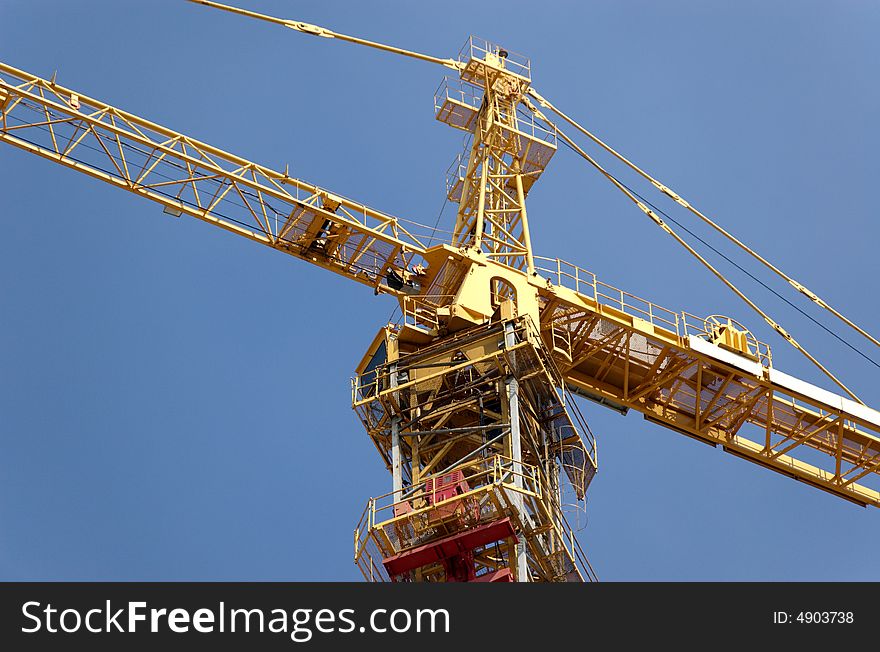 Lifting crane building the house on a blue sky