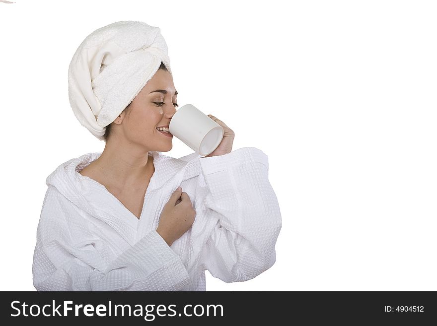 A young woman with bathclothes isolated on white while drinking a cup of milk. A young woman with bathclothes isolated on white while drinking a cup of milk