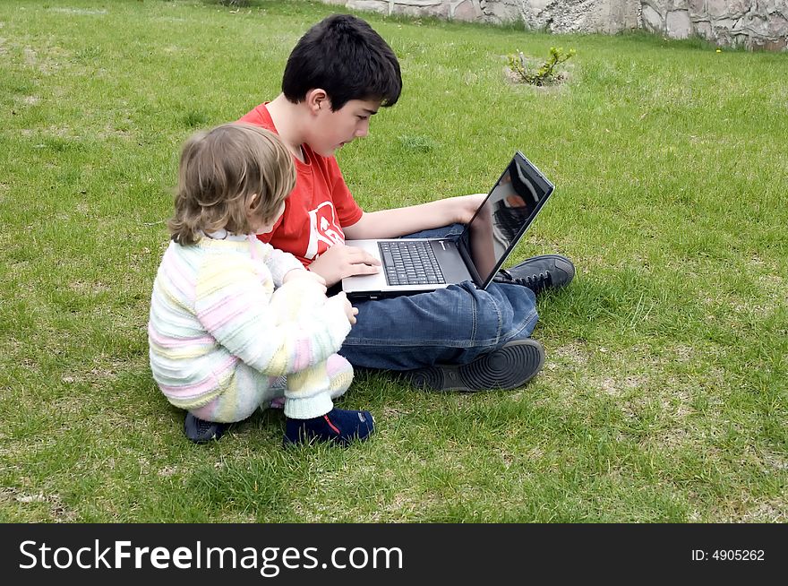 Boy and the girl with the laptop,in the garden. Boy and the girl with the laptop,in the garden