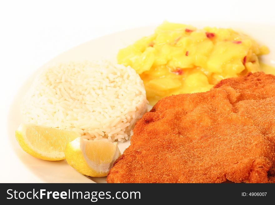 Traditional  viennese Schnitzel with potato salad and rice on a withe background.