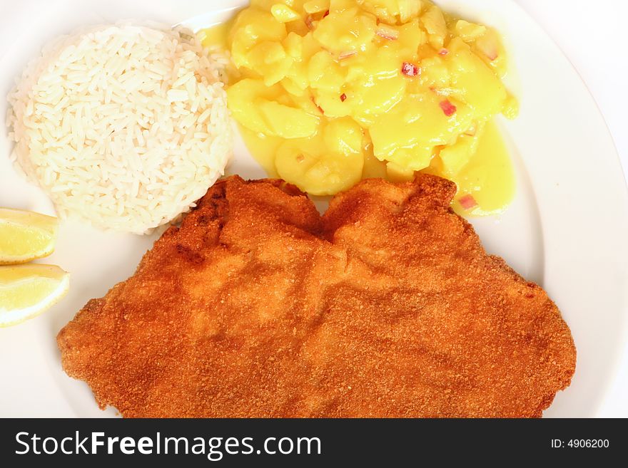 Traditional  viennese Schnitzel with potato salad and rice on a withe background.