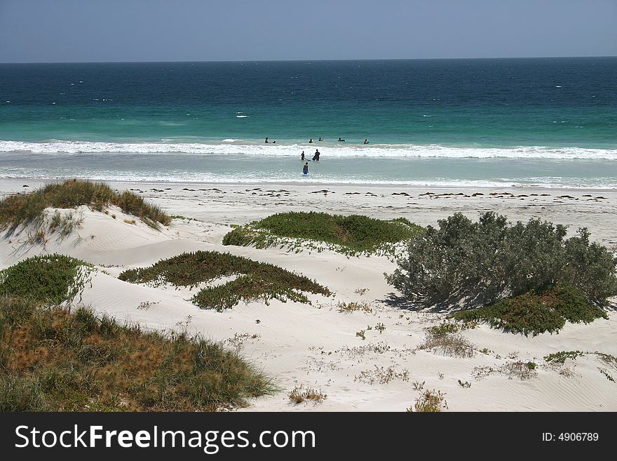 Small group of young people learning to surf in the ocean water. Australia