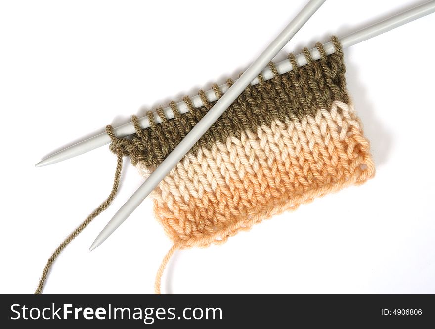 Knitting a color fluffy wooll, with knitting needles. Isolated on white