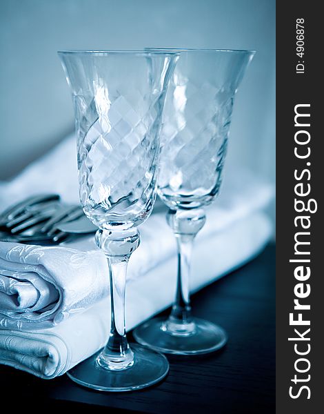 White napkin and two empty glasses for a sparkling wine on a black surface. White napkin and two empty glasses for a sparkling wine on a black surface