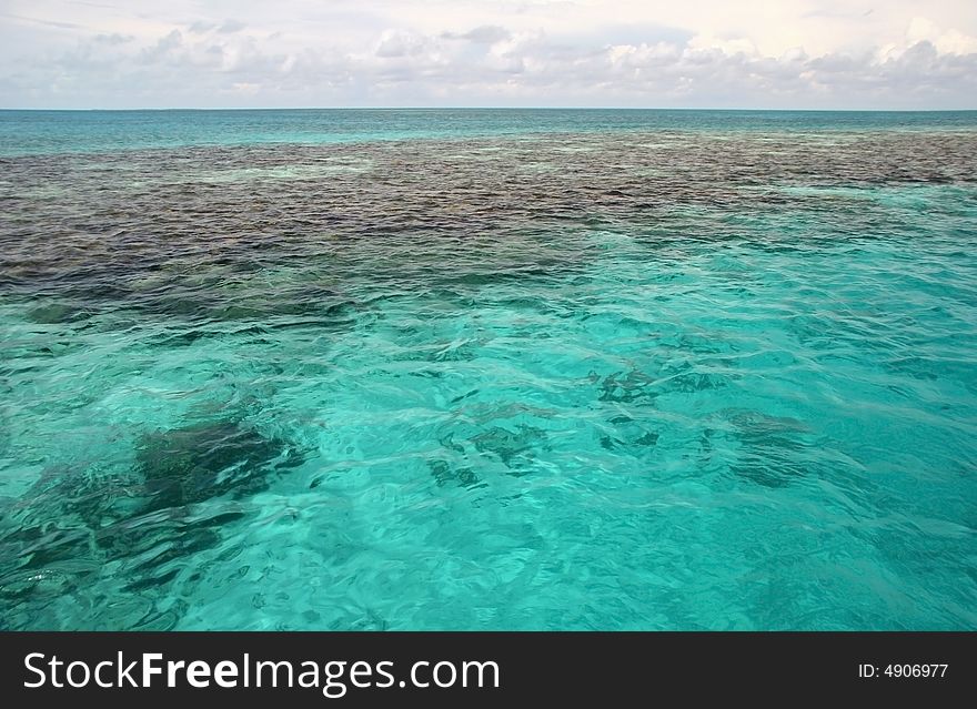 Black rocks in turquoise ocean water. Blue hole, Belize