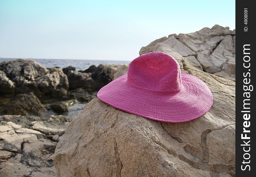 Pink hat on rocky beach. Pink hat on rocky beach.