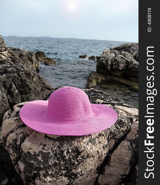 Pink hat on rocky beach in Croatia. Pink hat on rocky beach in Croatia.