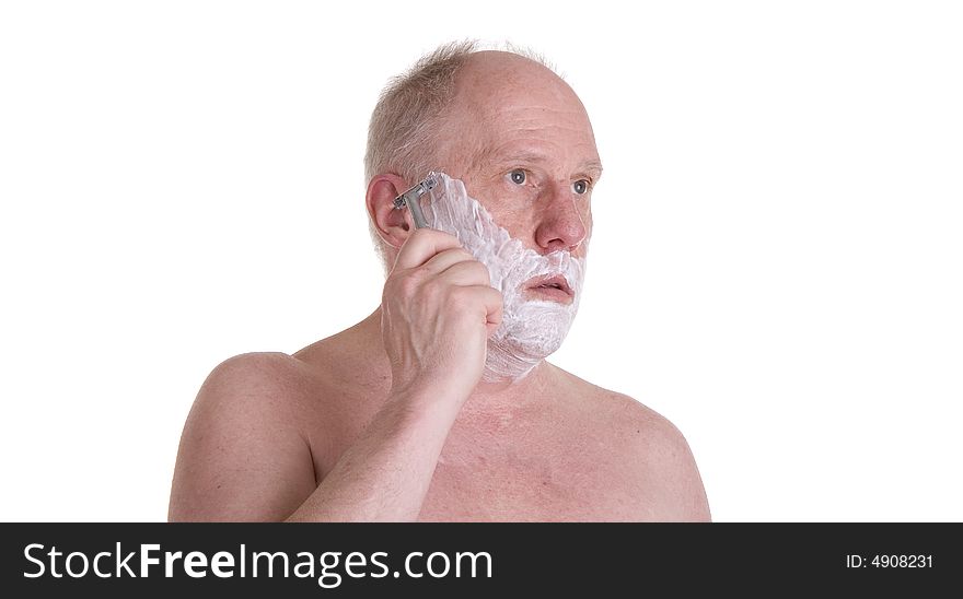 A man with shaving cream about to shave his face, looking in the mirror. A man with shaving cream about to shave his face, looking in the mirror