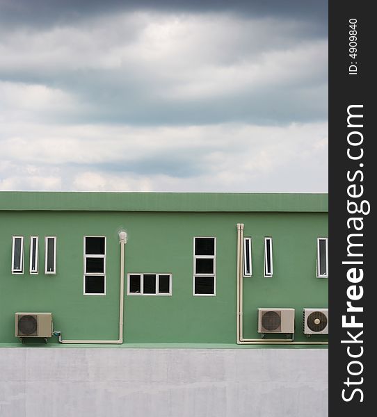 Exterior of an industrial building with dark clouds in the sky. Exterior of an industrial building with dark clouds in the sky.