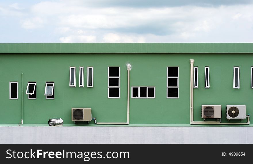 Exterior of an industrial building with dark clouds in the sky. Exterior of an industrial building with dark clouds in the sky.