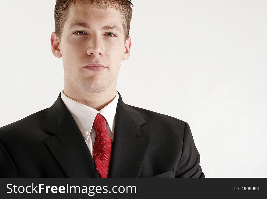 Young businessman wearing dark suit with red necktie